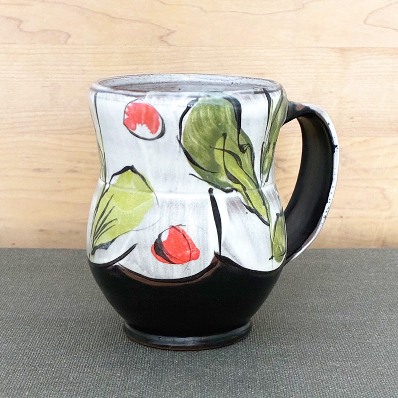 Handmade ceramic mug, black and white with abstracted orange floral with green leaves by Renata Copeland. 