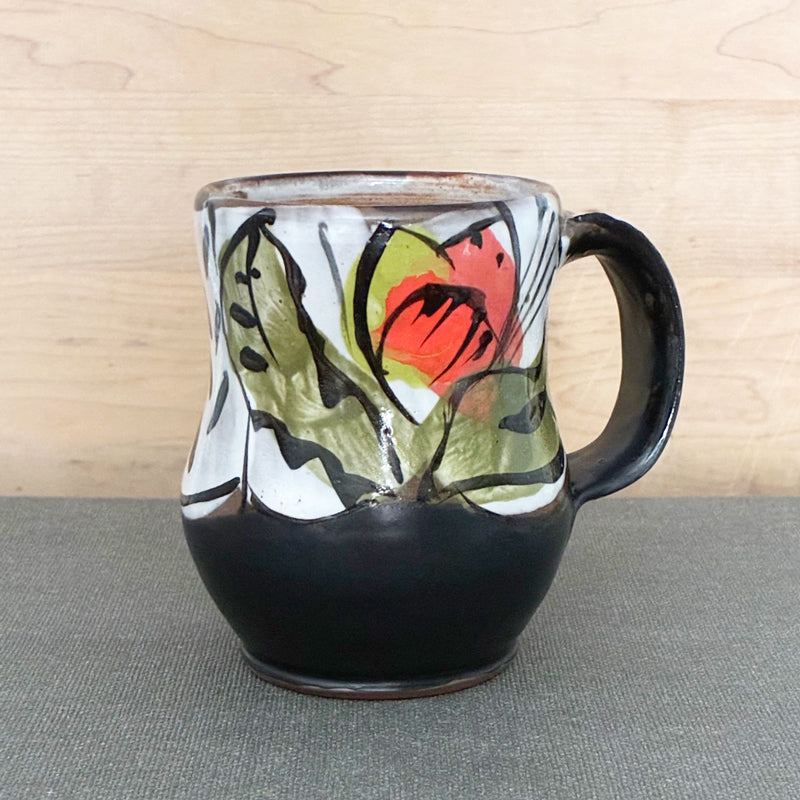 Handmade ceramic mug, black and white with orange and chartreuse floral with green leaves by Renata Copeland. 