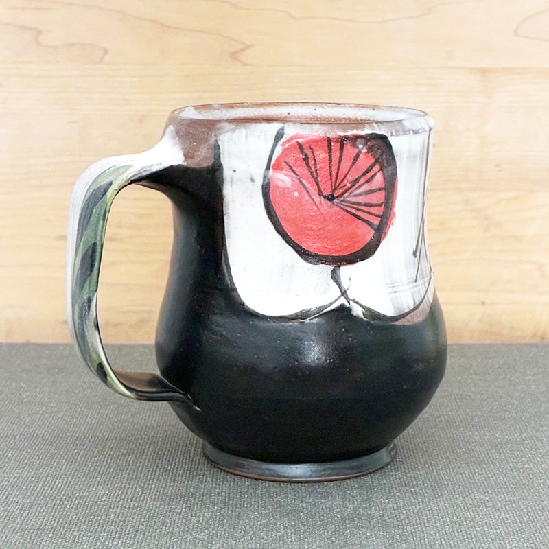Handmade ceramic mug, black and white with abstracted red floral design by Renata Copeland. Alternate view.