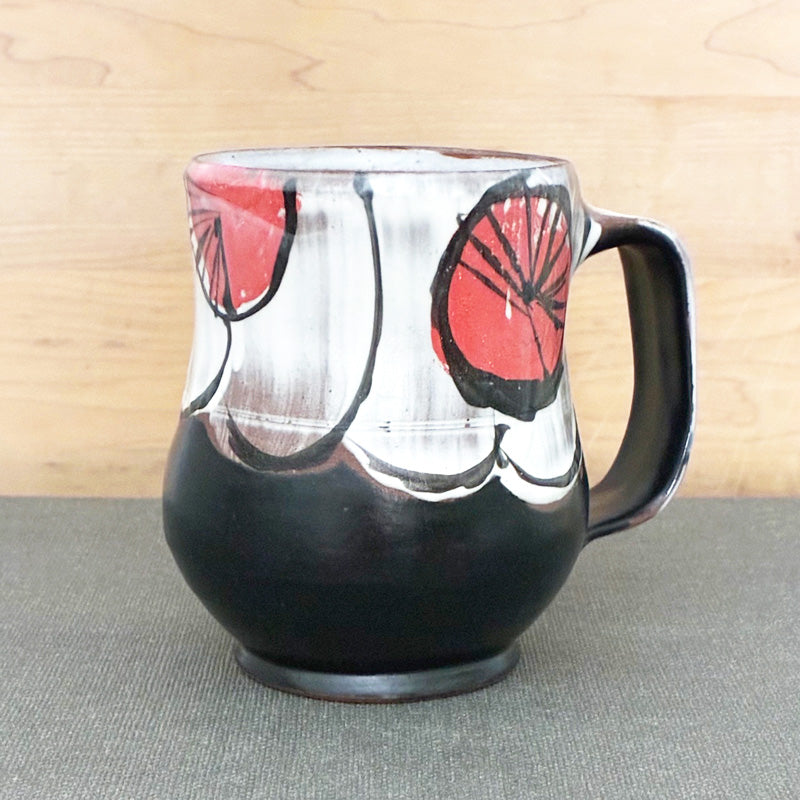 Handmade ceramic mug, black and white with abstracted red floral design by Renata Copeland. 