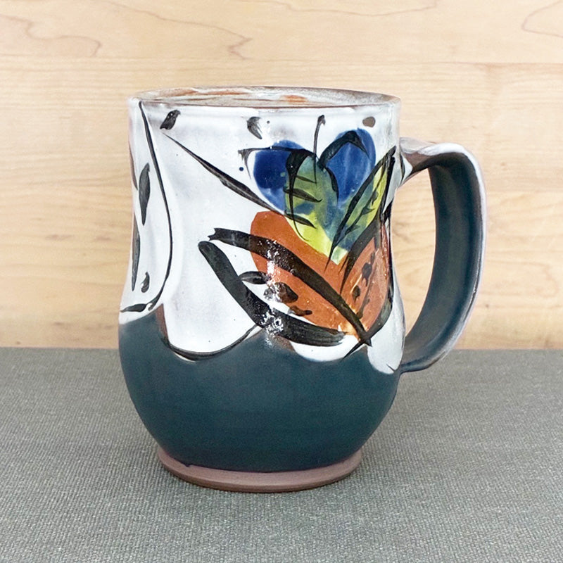 Handmade ceramic mug, dark blue and white with bright blue floral design by Renata Copeland. 