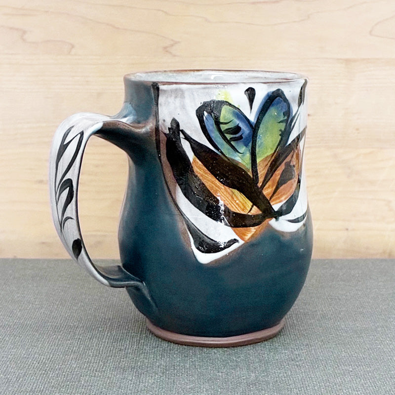 Handmade ceramic mug, dark blue and white with bright blue floral design by Renata Copeland. 