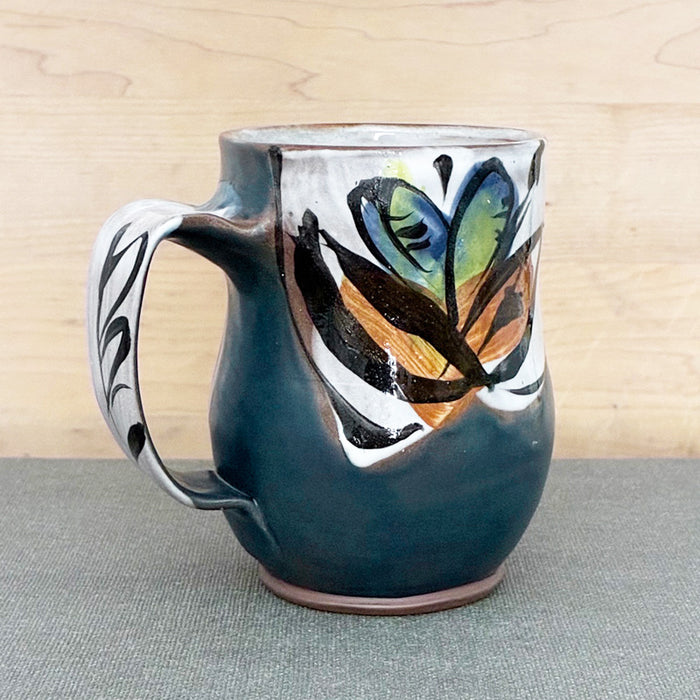 Handmade ceramic mug, dark blue and white with bright blue floral design by Renata Copeland. 