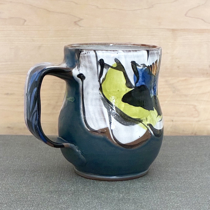 Handmade ceramic mug, blue and white with blue floral design and chartreuse leaves by Renata Copeland. Alternate view.