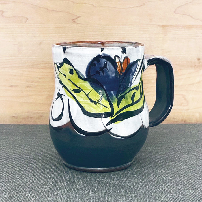Handmade ceramic mug, blue and white with blue floral design and chartreuse leaves by Renata Copeland. 