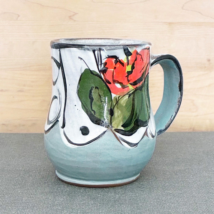 Handmade ceramic mug, light blue and white with bright orange floral design by Renata Copeland. Alternate view. 
