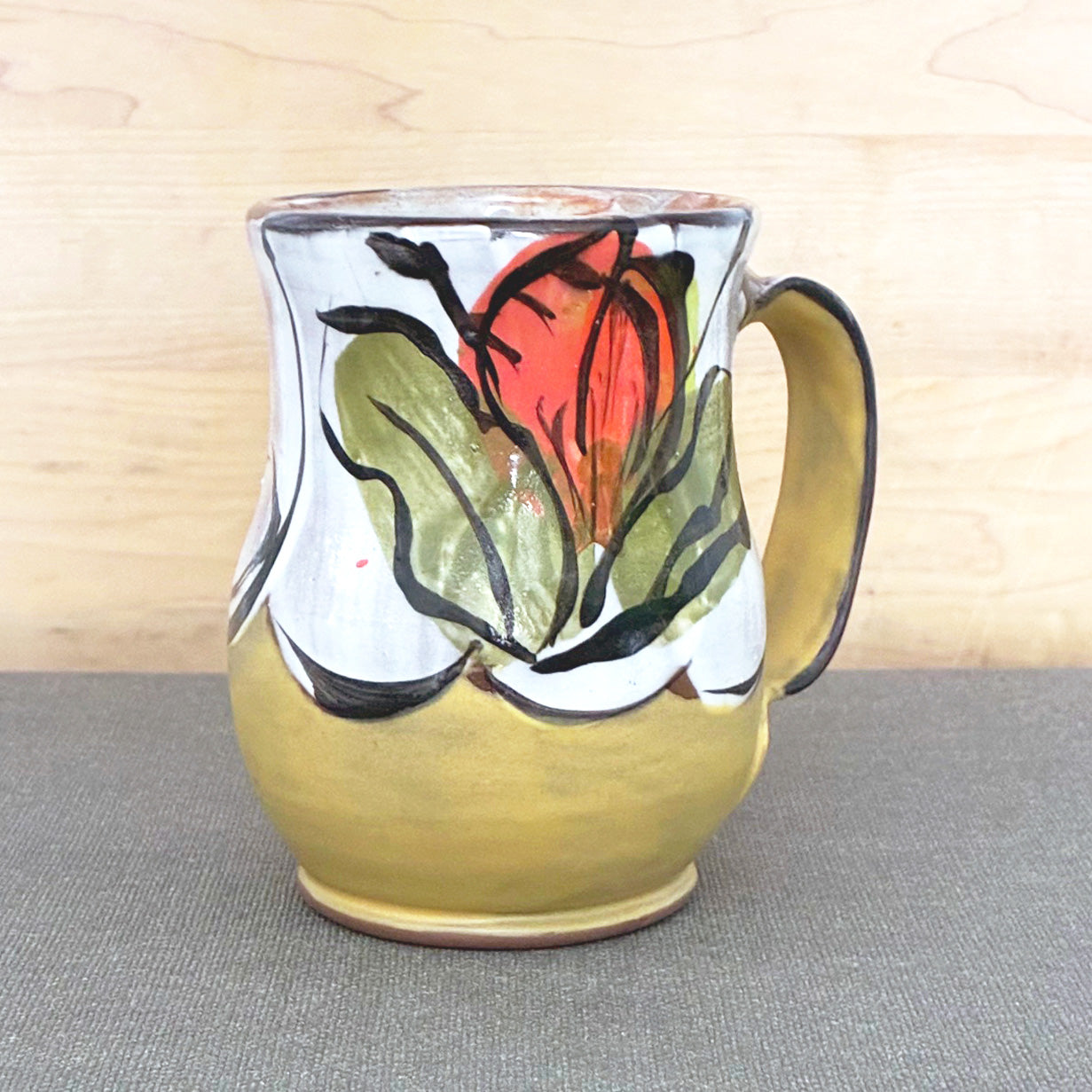 Handmade ceramic mug, yellow and white with bright orange floral design by Renata Copeland. 
