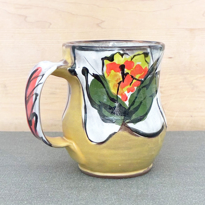 Handmade ceramic mug, yellow and white with bright orange and chartreuse floral design by Renata Copeland. Alternate view. 