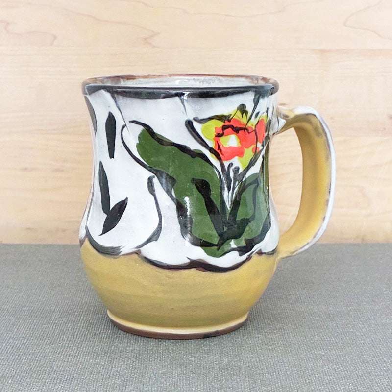 Handmade ceramic mug, yellow and white with bright orange and chartreuse floral design by Renata Copeland. 