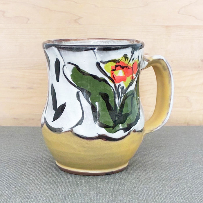 Handmade ceramic mug, yellow and white with bright orange and chartreuse floral design by Renata Copeland. 