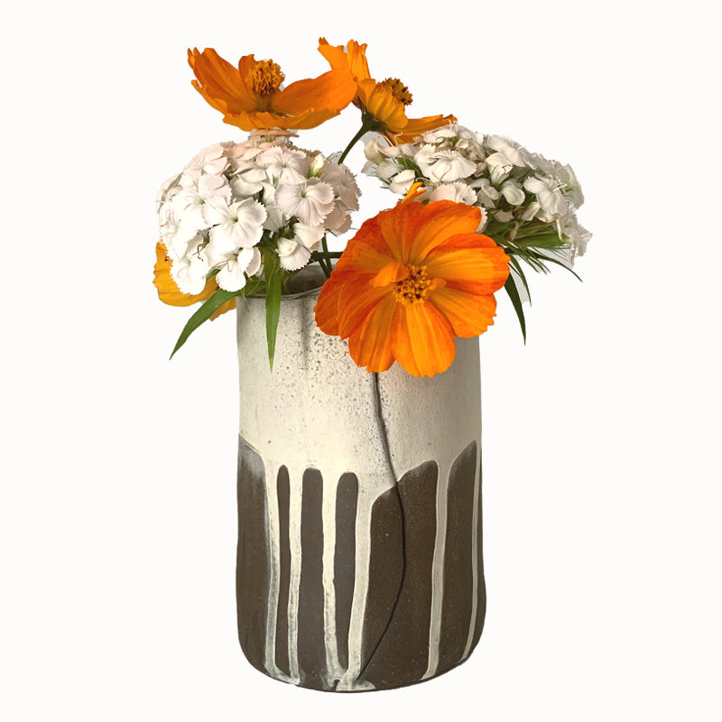 Small dark brown and white drippy vase by ceramic artist Robin Ralston Frelier. Shown with orange and white flowers.