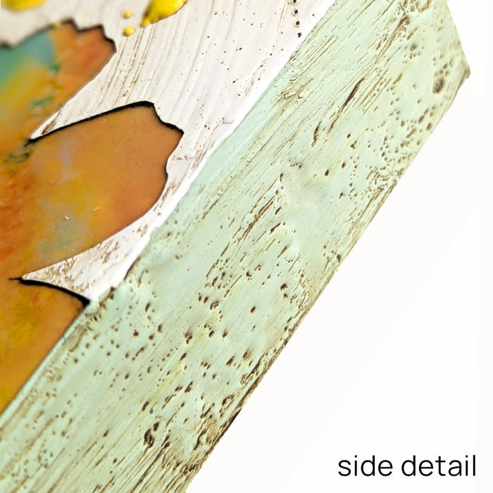 Bloom No. 12, small mixed media painting by artist Sarah Treanor. Orange and aqua textural, floral artwork created with digital prints of the  artist's cyanotypes and eco prints underneath layers of encaustic paint, with splatters of yellow encaustic on top. Side detail shown.