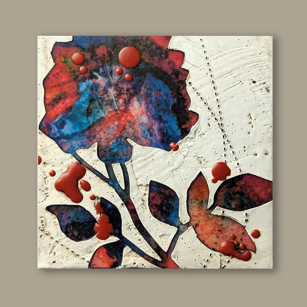 Bloom No. 15, small mixed media painting by artist Sarah Treanor. Red and blue textural, floral artwork created with digital prints of the  artist's cyanotypes and eco prints underneath layers of encaustic paint, with splatters of red encaustic on top. Shown on tan wall.