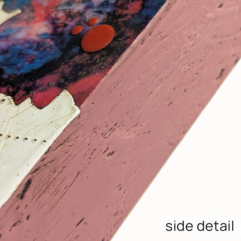 Bloom No. 15, small mixed media painting by artist Sarah Treanor. Red and blue textural, floral artwork created with digital prints of the  artist's cyanotypes and eco prints underneath layers of encaustic paint, with splatters of red encaustic on top. Pink side detail shown.