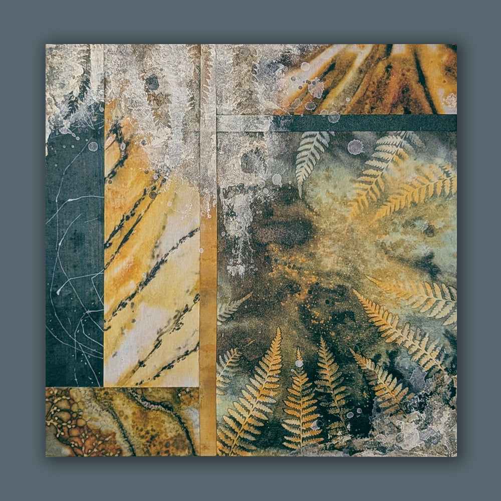 "Sacred Seeds" mixed media, abstracted wall art by Sarah Treanor. 10 x 10" nature inspired cyanotype, eco-print and acrylic artwork with ferns, in earthy blues, yellow golds, grays and creams. Shown on blue wall. 