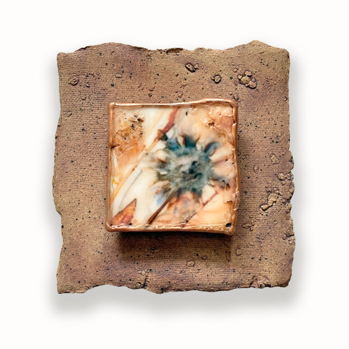 Textured and irregular shaped ceramic tile with mixed media flower design in the center. Artwork by Sarah Treanor. 