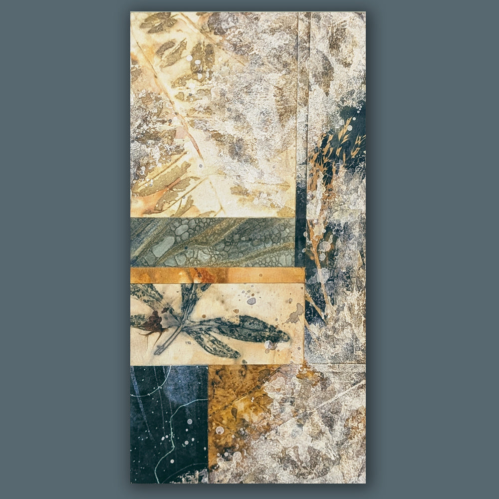 "Veil of the Underwood" mixed media, abstracted wall art by Sarah Treanor. 12 x 6" nature inspired cyanotype, eco-print and acrylic artwork in earthy blues, yellow golds, grays and creams. Shown on blue wall.