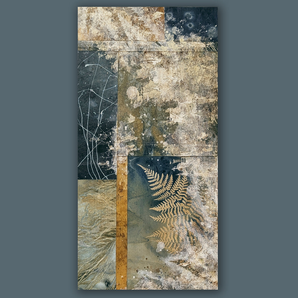 "Veil of the Underwood" mixed media, abstracted wall art by Sarah Treanor. 12 x 6" nature inspired cyanotype, eco-print and acrylic artwork with fern in earthy blues, yellow golds, grays and creams. Shown on blue wall.