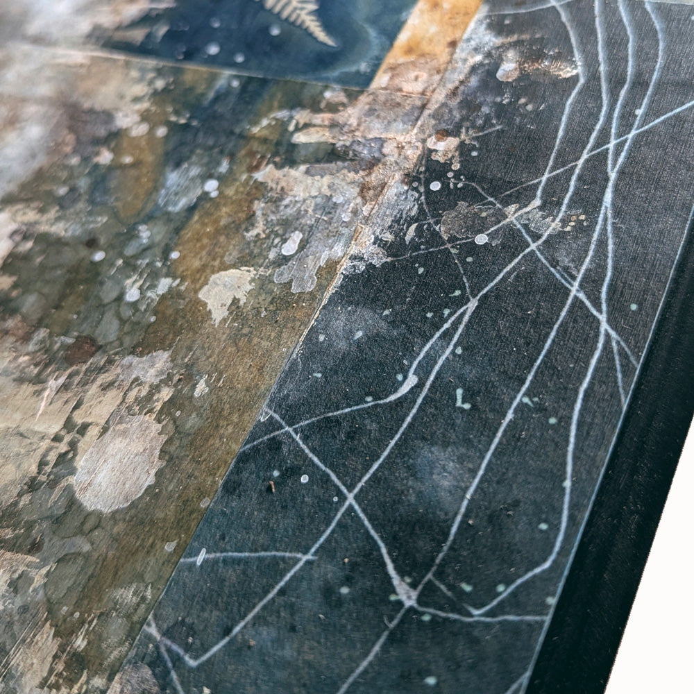 "Veil of the Underwood" mixed media, abstracted wall art by Sarah Treanor. 12 x 5" cyanotype, eco-print and acrylic artwork in earthy blues, yellow golds, grays and creams. Detail shown.