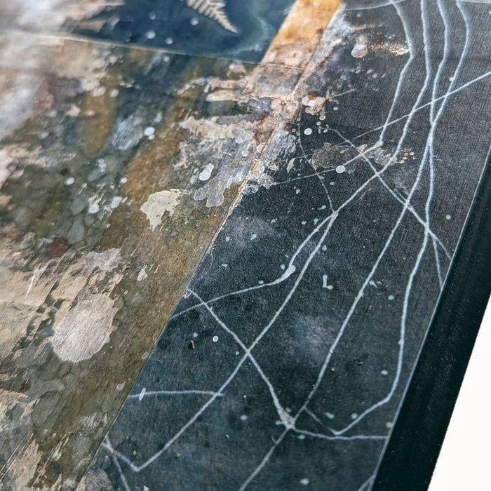 "Veil of the Underwood" mixed media, abstracted wall art by Sarah Treanor. 12 x 5" cyanotype, eco-print and acrylic artwork in earthy blues, yellow golds, grays and creams. Detail shown.