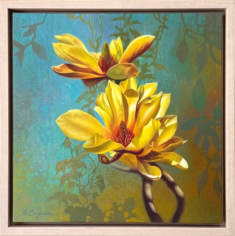 Oil painting featuring two bright yellow magnolia flowers  against a textured blue and green botanical background. The artwork, by Sharon Cosgrove, is set in a hardwood maple frame. 