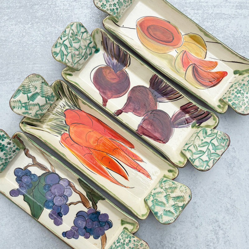 Set of four handmade serving trays by Molly Lithgo with grape, carrot, beet and cantaloupe decoration. 