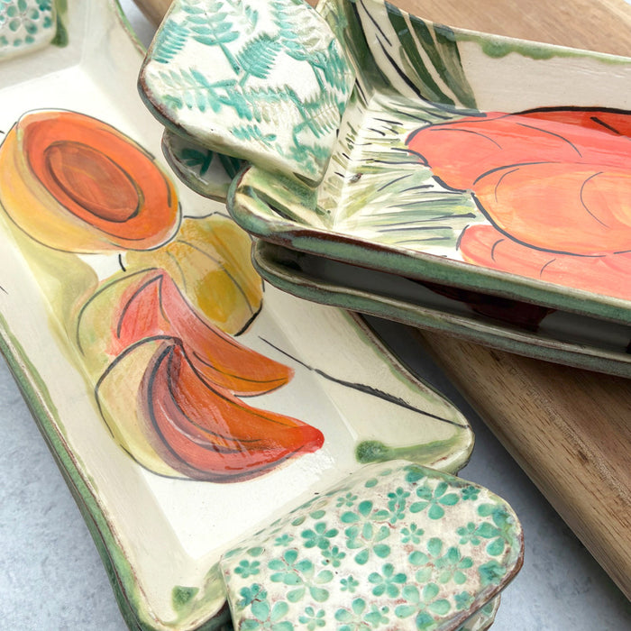 Handmade ceramic serving trays by Molly Lithgo with cantaloupe an carrot decoration.