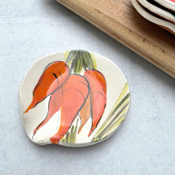 Handmade ceramic spoon rest with carrot decoration by artist Molly Lithgo.