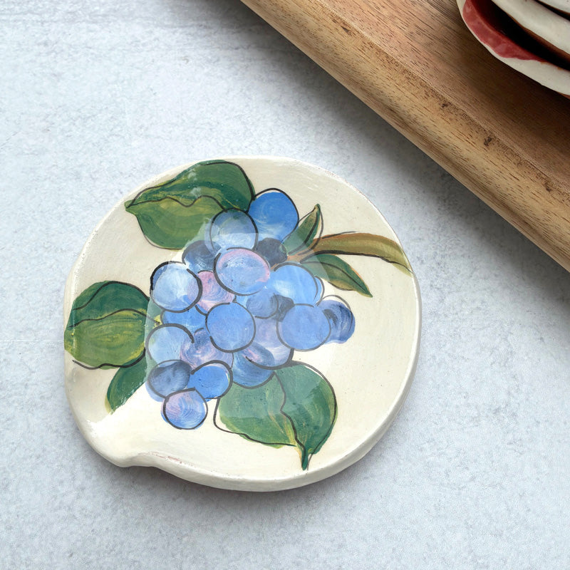 Handmade ceramic spoon rest with grape decoration by artist Molly Lithgo.