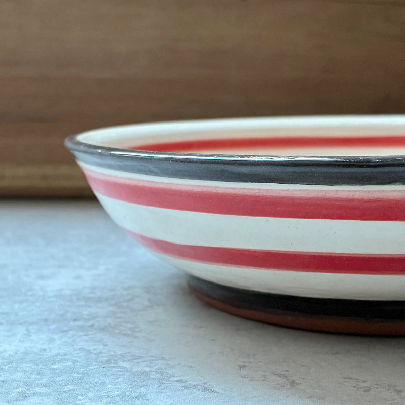 Handmade ceramic bowl with strawberry decoration on the interior by artist Molly Lithgo.  Side view.