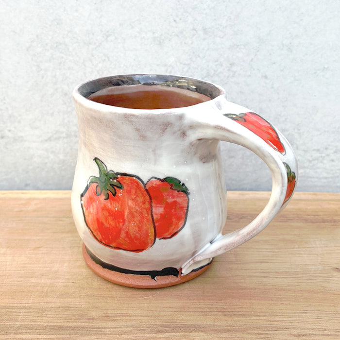 Handmade ceramic mug by NC potter Molly Lithgo. White with strawberry decoration. View with handle detail.