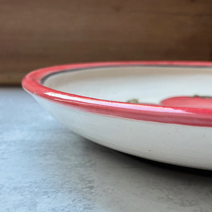Handmade ceramic shallow serving bowl with tomato decoration by Molly Lithgo. Side view.